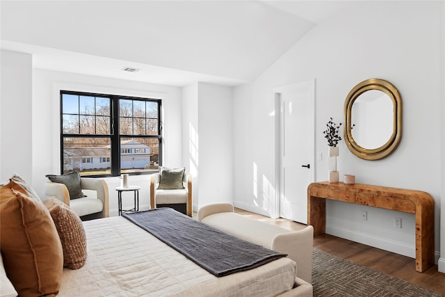 bedroom with dark wood-type flooring and lofted ceiling