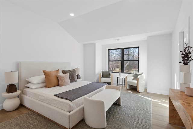 bedroom with wood-type flooring and vaulted ceiling