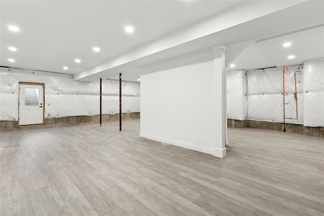 basement with light hardwood / wood-style flooring