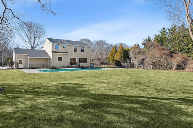 back of house with a patio, a covered pool, and a lawn