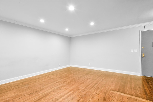 spare room featuring crown molding and light hardwood / wood-style flooring