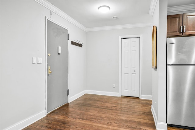 interior space with ornamental molding, dark hardwood / wood-style floors, and stainless steel fridge