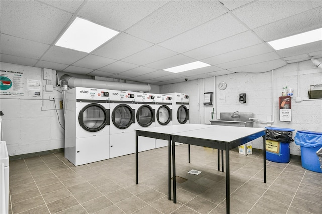 clothes washing area with light tile patterned flooring and washer and clothes dryer