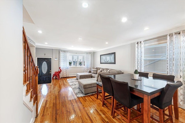 dining space featuring crown molding and light wood-type flooring