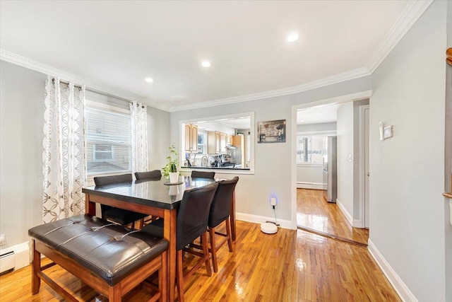 dining area featuring crown molding, light hardwood / wood-style floors, and baseboard heating