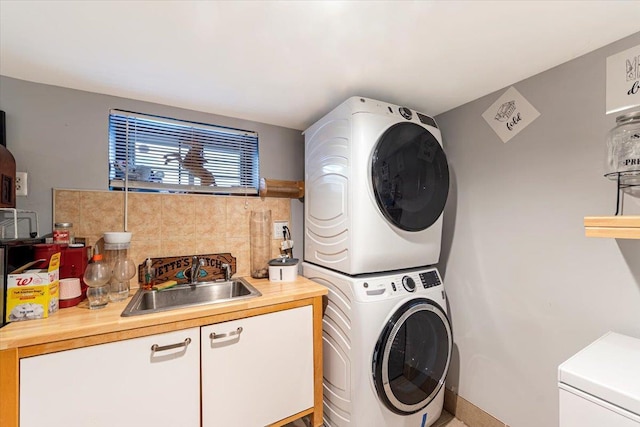 clothes washing area featuring stacked washer and clothes dryer and sink