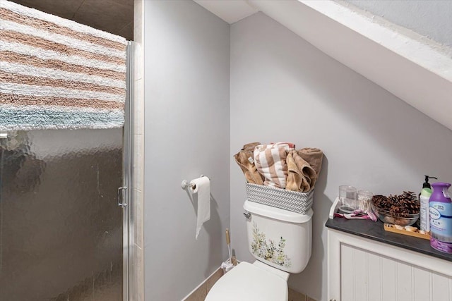 bathroom featuring lofted ceiling, toilet, and an enclosed shower