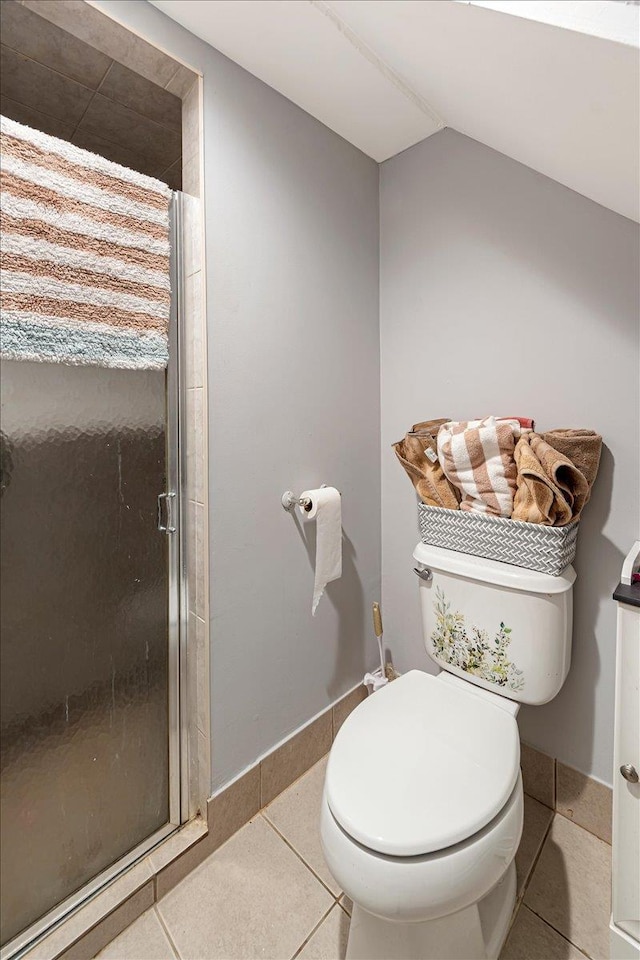 bathroom featuring tile patterned flooring, a shower with shower door, lofted ceiling, and toilet