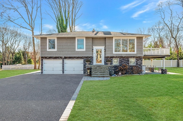 bi-level home featuring a garage and a front lawn