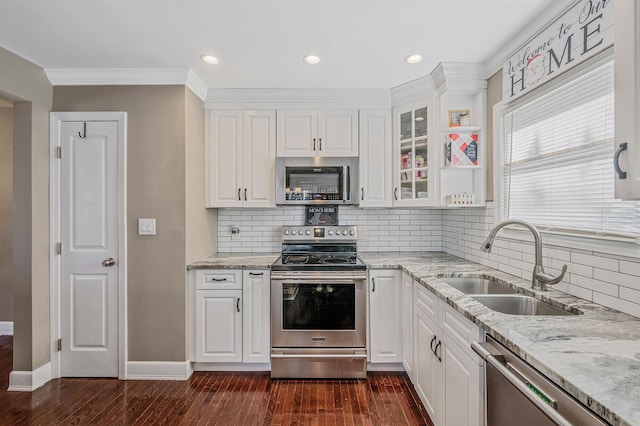 kitchen featuring appliances with stainless steel finishes, sink, white cabinets, light stone counters, and dark wood-type flooring