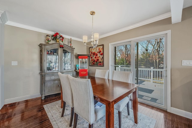 dining area featuring crown molding, dark hardwood / wood-style floors, and a notable chandelier