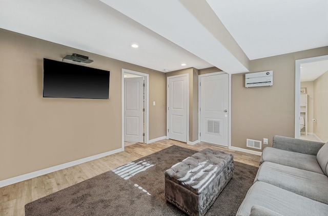 living room featuring hardwood / wood-style floors and a wall unit AC