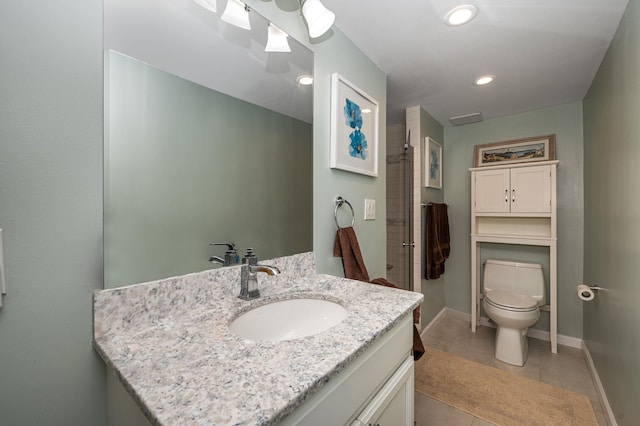 bathroom with vanity, toilet, a shower with shower door, and tile patterned flooring