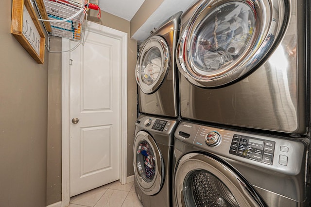 washroom with stacked washer and clothes dryer and light tile patterned floors