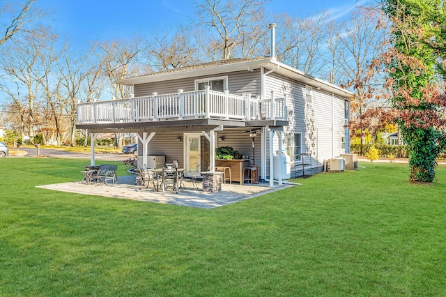 back of property with a bar, a wooden deck, a yard, and a patio