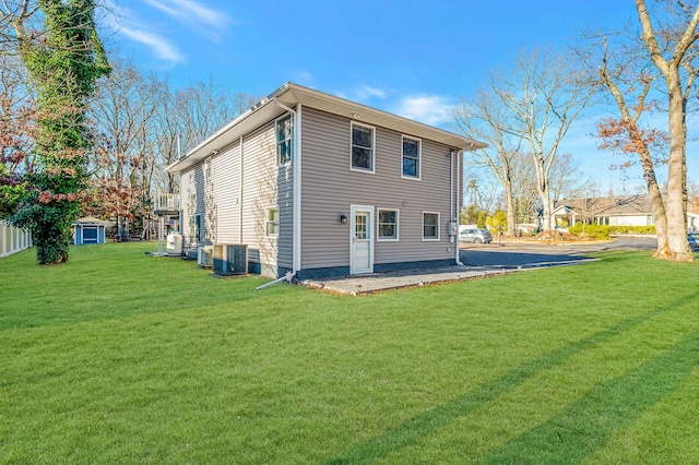 rear view of house with a lawn and central air condition unit