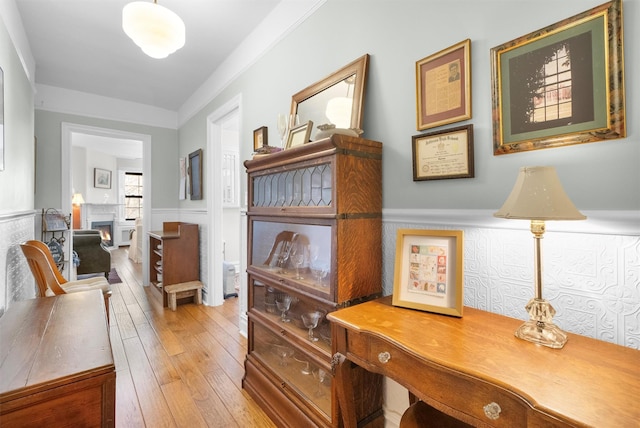 hallway featuring ornamental molding and hardwood / wood-style floors