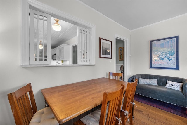 dining space with crown molding and wood-type flooring