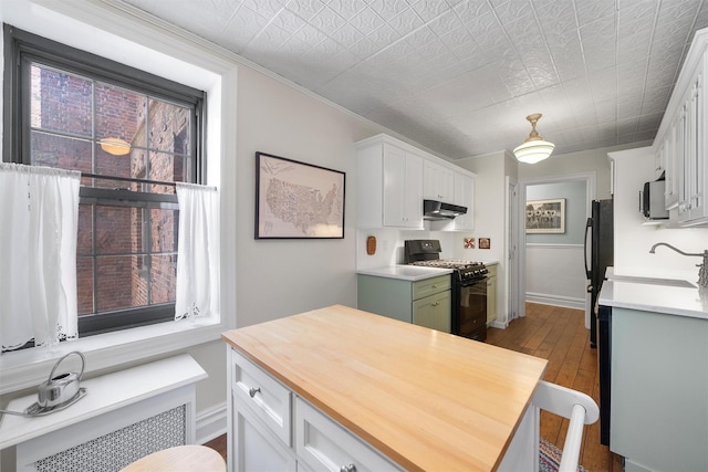 kitchen featuring sink, light hardwood / wood-style flooring, white cabinetry, radiator heating unit, and black appliances