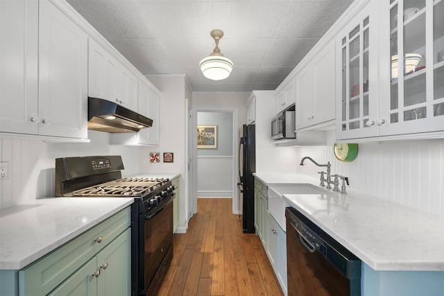 kitchen featuring sink, green cabinets, white cabinetry, black appliances, and light wood-type flooring