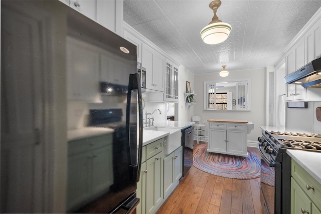 kitchen featuring white cabinetry, light hardwood / wood-style flooring, black appliances, and green cabinetry