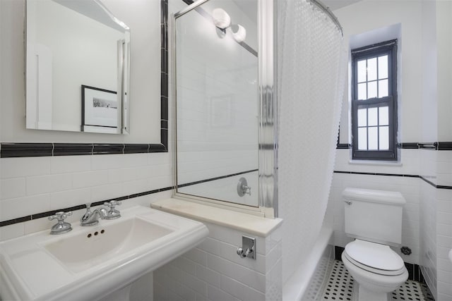 full bathroom featuring shower / tub combo with curtain, sink, tile walls, tile patterned flooring, and toilet