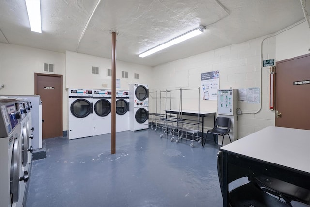 laundry area with a textured ceiling and stacked washing maching and dryer