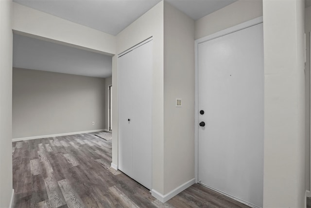 hallway featuring wood finished floors and baseboards