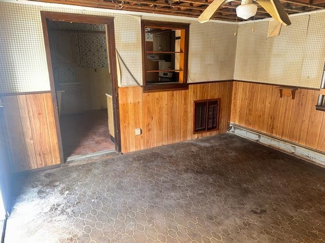 carpeted empty room with wooden walls