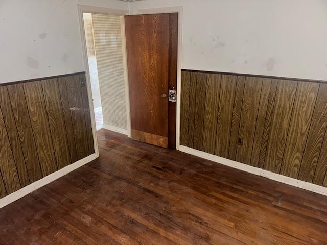 empty room featuring wooden walls and dark hardwood / wood-style floors