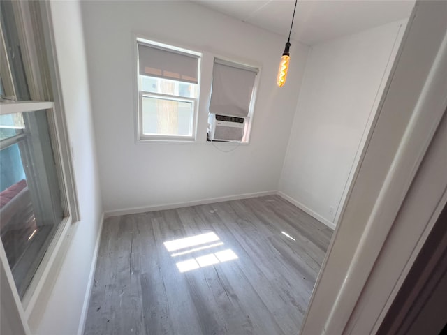 empty room featuring cooling unit and light hardwood / wood-style floors