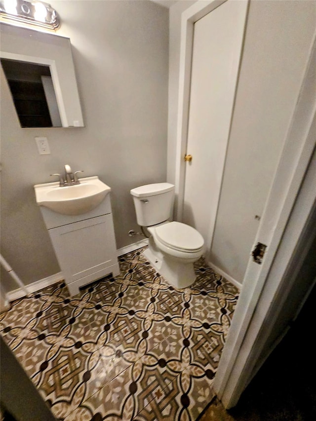 bathroom featuring tile patterned flooring, vanity, and toilet