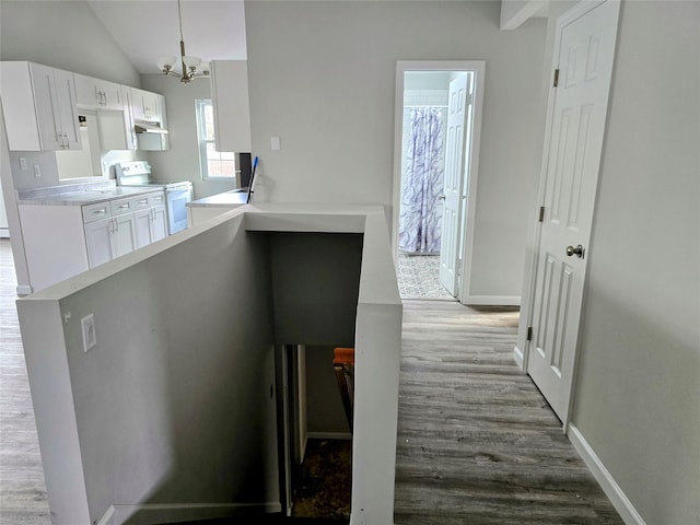 corridor with lofted ceiling, hardwood / wood-style floors, and a chandelier