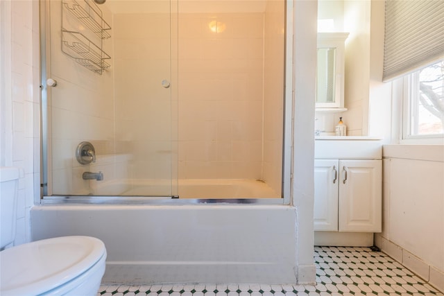 full bathroom featuring vanity, combined bath / shower with glass door, and toilet