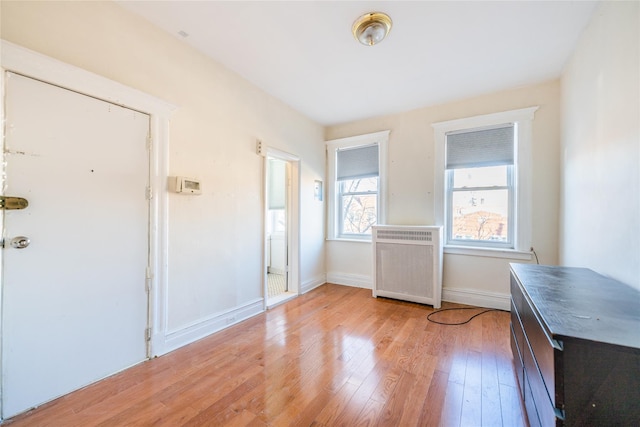 interior space featuring radiator heating unit and light hardwood / wood-style flooring