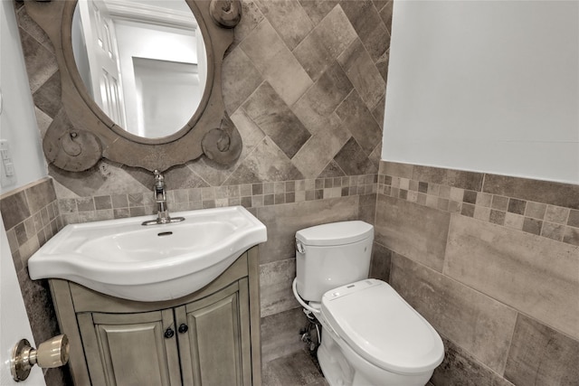 bathroom featuring vanity, toilet, and tile walls