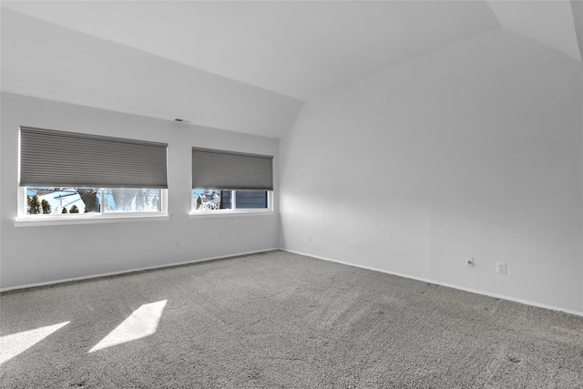 empty room with vaulted ceiling and carpet