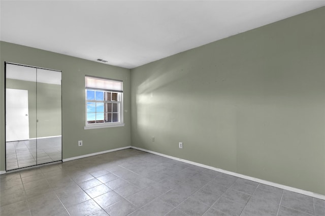 unfurnished bedroom featuring a closet and light tile patterned floors