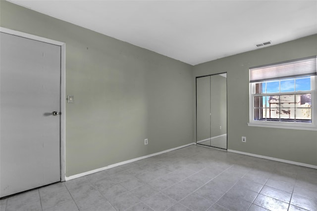 unfurnished bedroom with a closet and light tile patterned floors