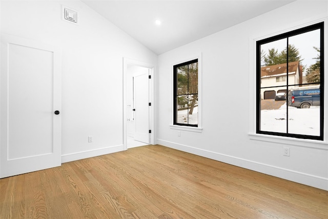 unfurnished room featuring vaulted ceiling and light wood-type flooring