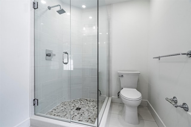 bathroom featuring tile patterned flooring, a shower with door, and toilet