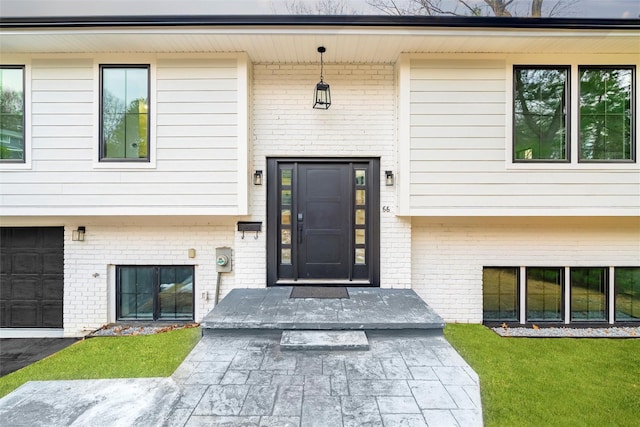 entrance to property featuring a yard and a garage