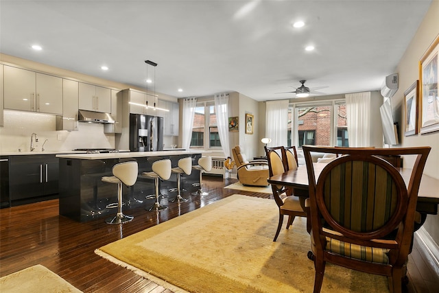 kitchen featuring tasteful backsplash, appliances with stainless steel finishes, dark hardwood / wood-style flooring, a kitchen island, and pendant lighting