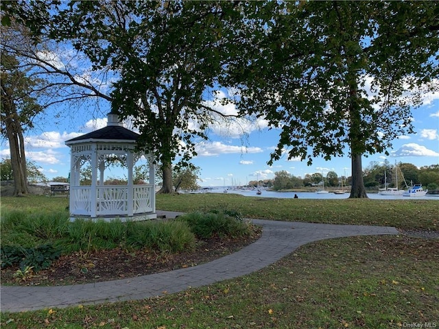 view of home's community with a gazebo, a water view, and a lawn