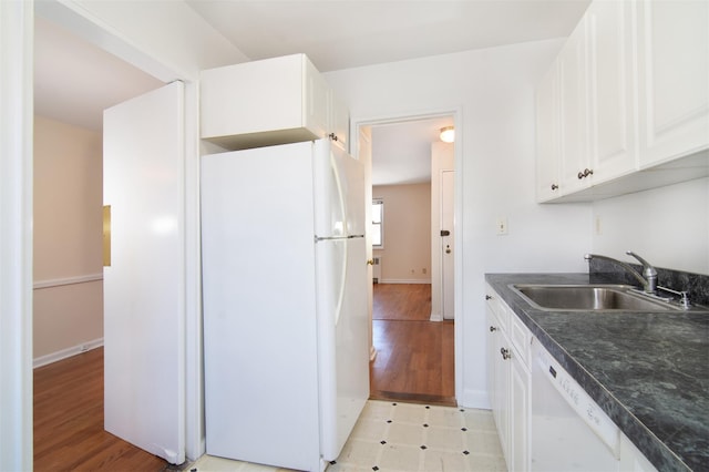 kitchen with white cabinetry, sink, white appliances, and light hardwood / wood-style floors