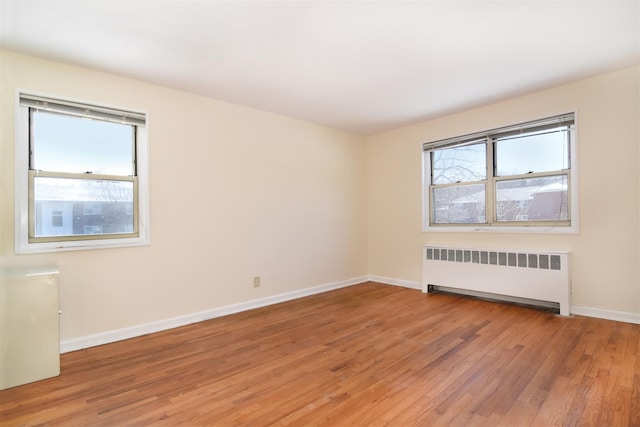 empty room with radiator heating unit and wood-type flooring