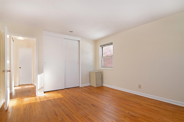 unfurnished bedroom with a closet and light wood-type flooring