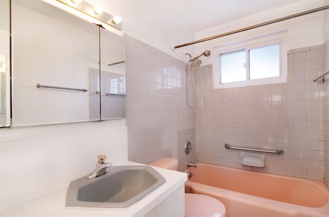 full bathroom with tiled shower / bath combo, sink, and toilet