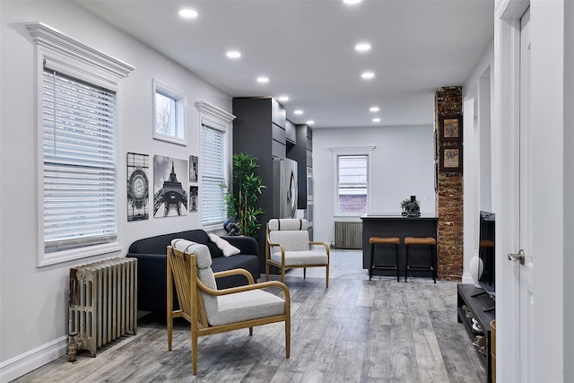 living area with radiator and light hardwood / wood-style flooring