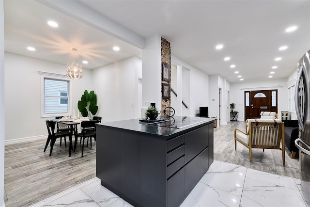 kitchen with decorative light fixtures, a chandelier, a center island, stainless steel fridge, and black electric stovetop